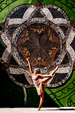 Dancer in gauzy, flowing costume balance on one foot and reaching up